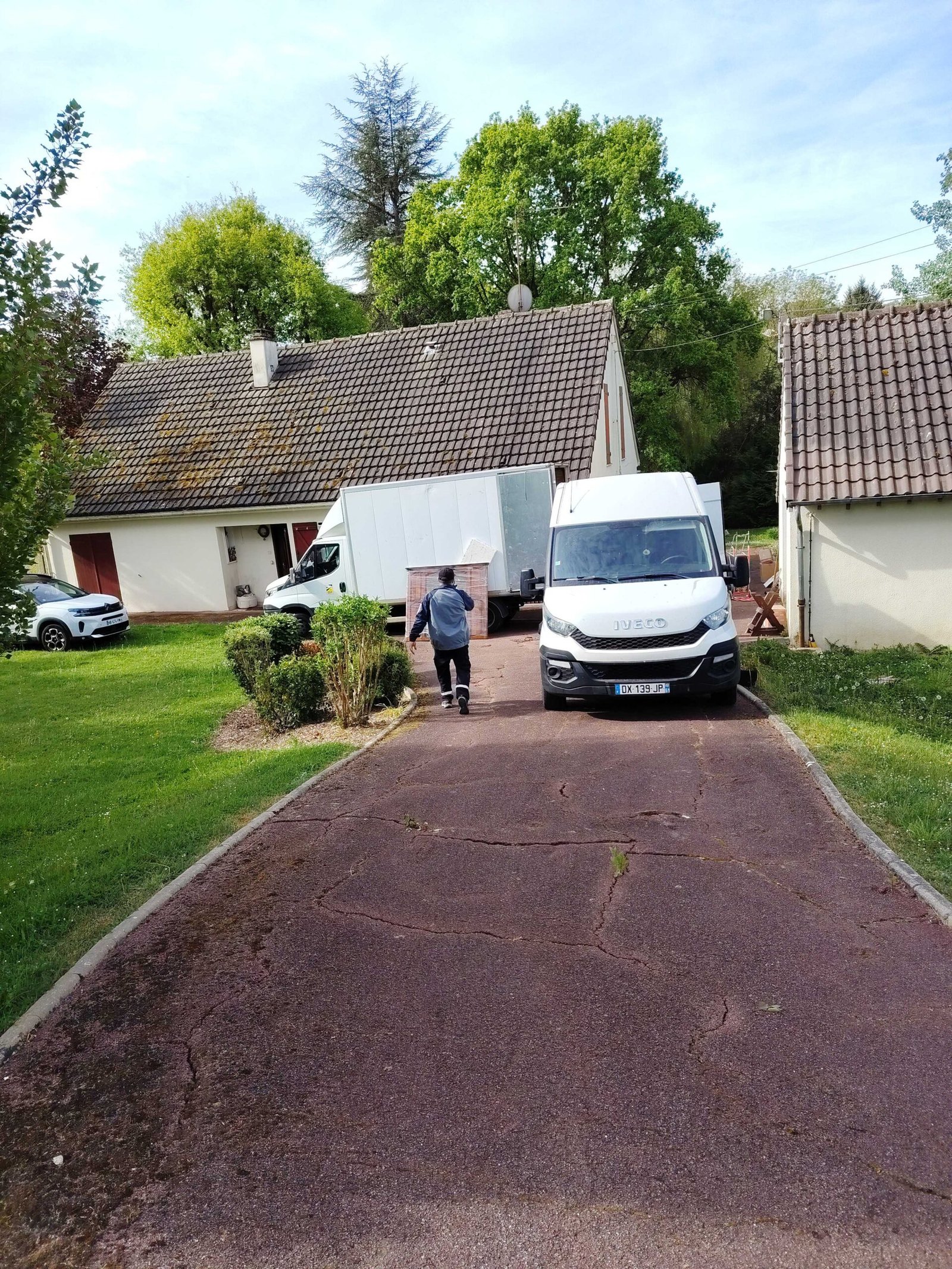 Camion de débarras professionnel Iveco devant une maison à Achères 78260 — Débarras Intégral Paris intervient dans les Yvelines